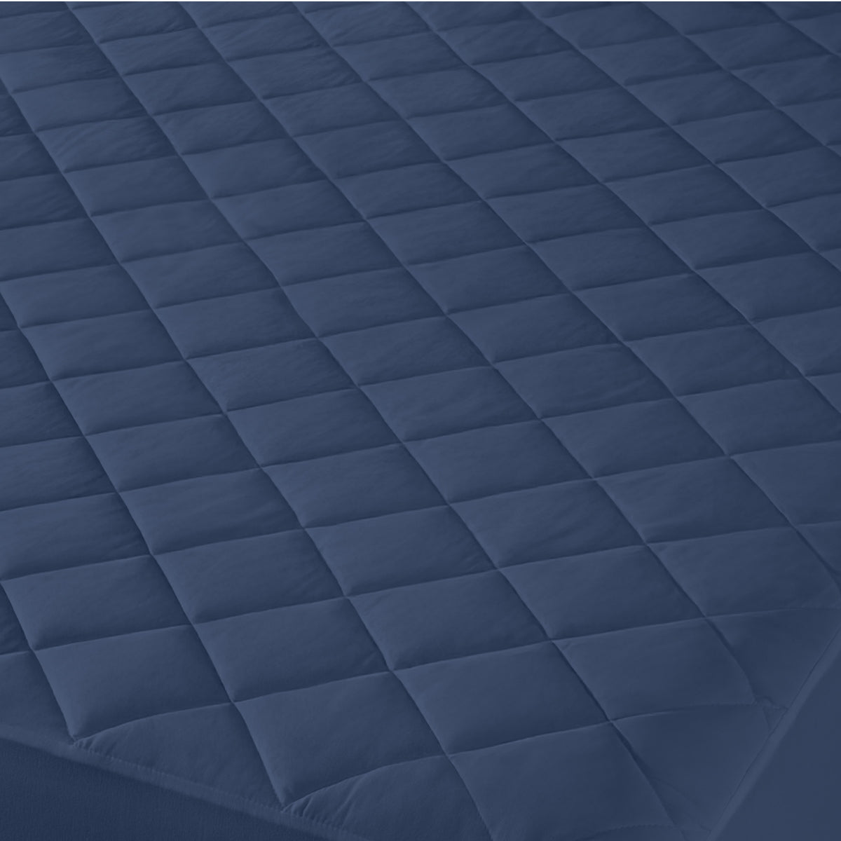 Close-up of a quilted mattress cover with a diamond pattern.