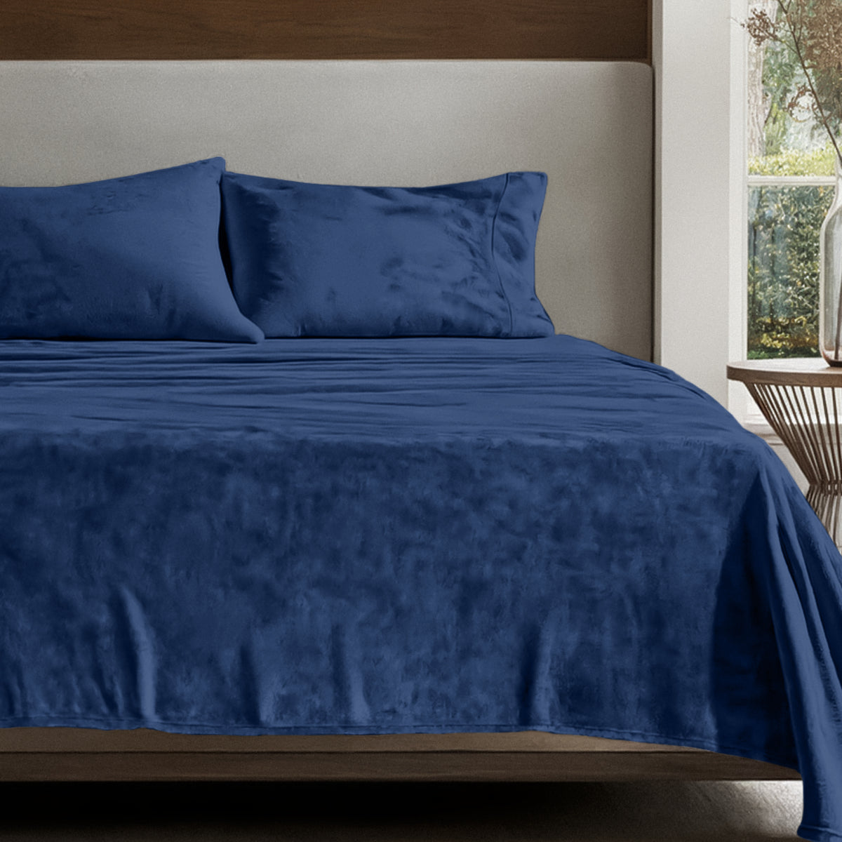 Microplush sheet set on a bed in a bedroom setting with a nightstand and lamp.