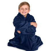 A boy is sitting while in a microplush wearable blanket.