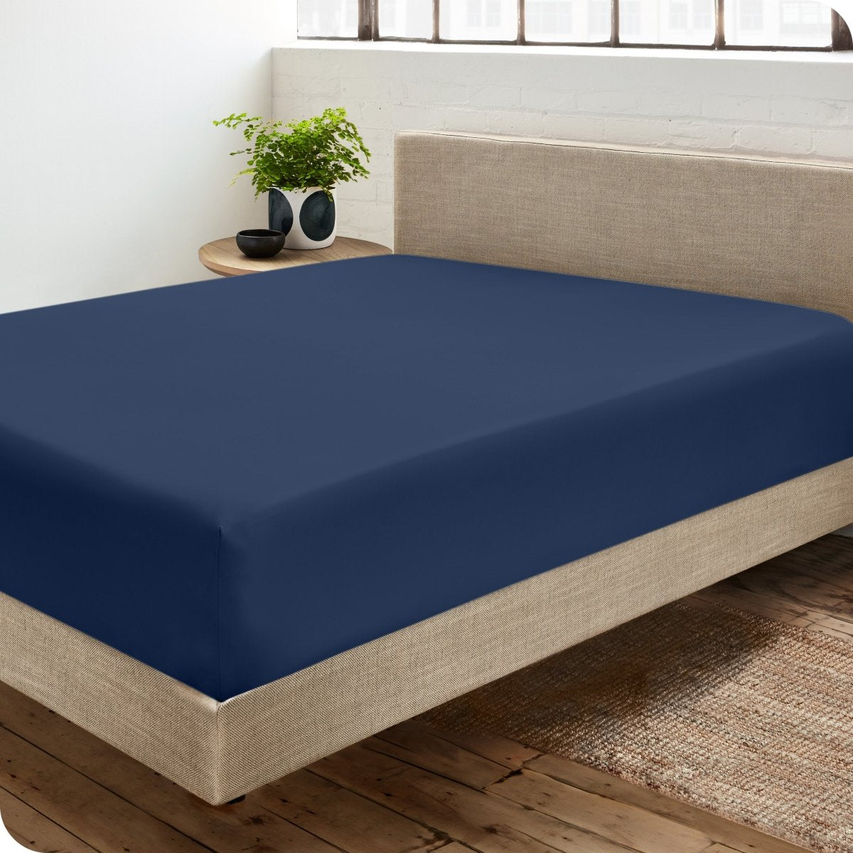 Diagonal view of modern bedroom with a sateen fitted sheet on the bed