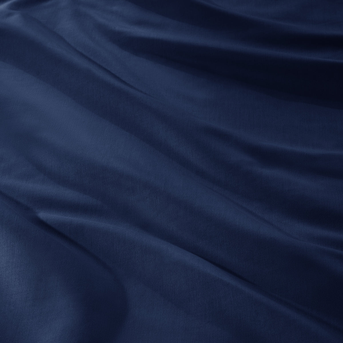 A close-up of draped sateen fabric with soft folds and a smooth texture.