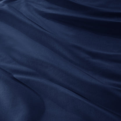 A close-up of draped sateen fabric with soft folds and a smooth texture.