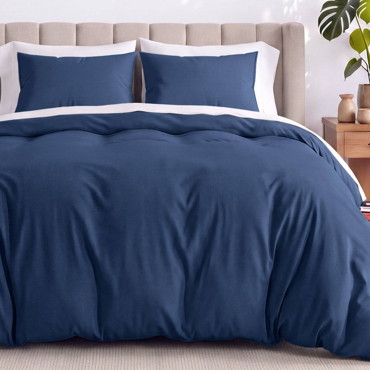 Neatly made bed with organic jersey bedding and pillow shams in a bedroom setting.