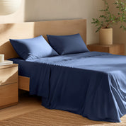 Bed with percale bedding and wooden headboard in a bedroom setting