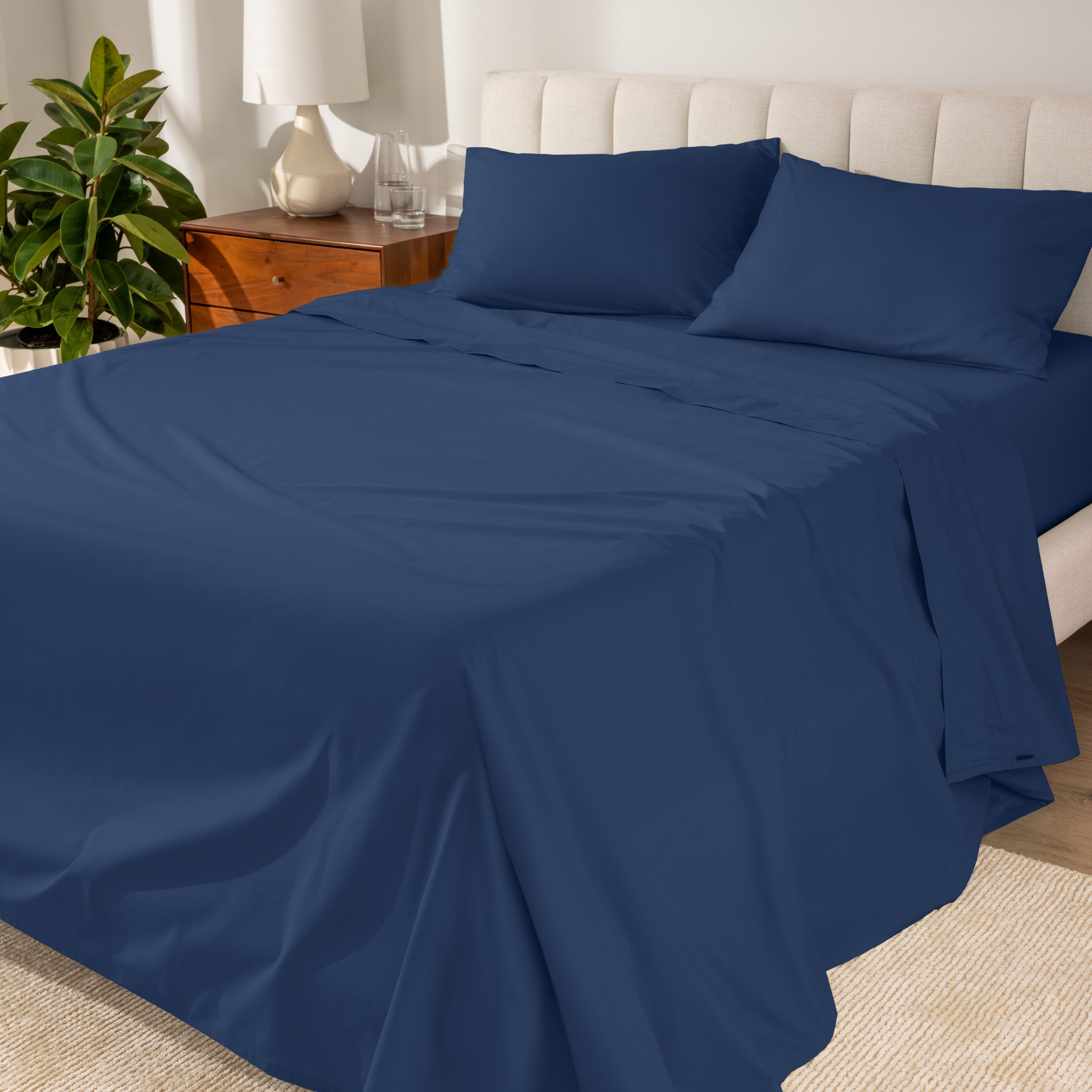 Percale sheets on a bed with a cream colored frame and headboard