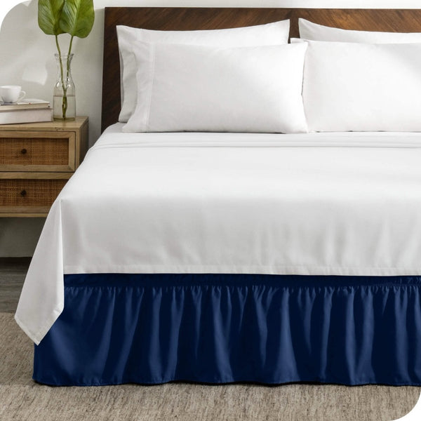 A wrap around bed skirt on a mattress with white bedding
