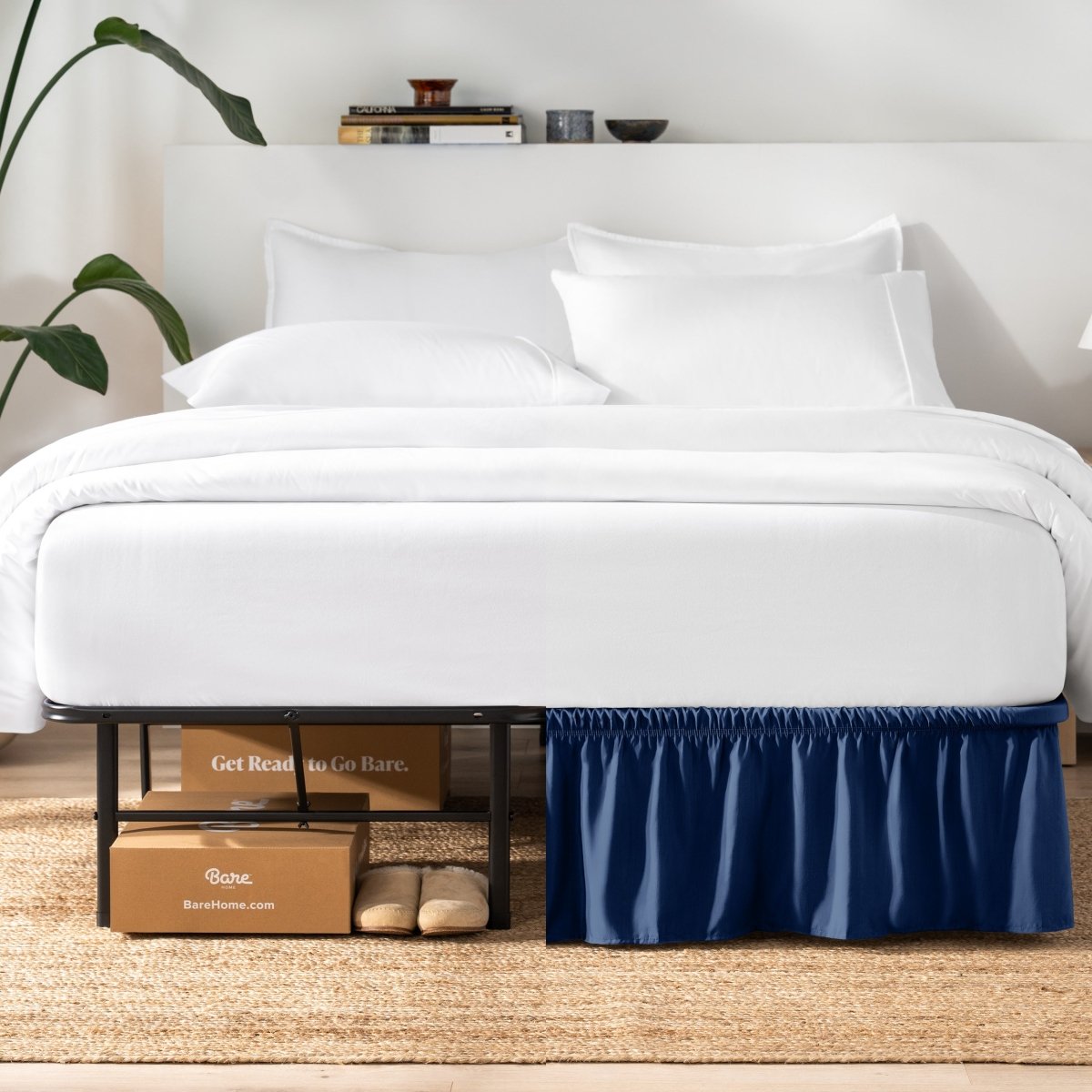Bed with white bedding and a plant near the bed.