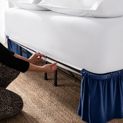 Adjustable bed skirt on a bed showing the elastic strap.