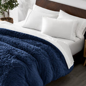 Shaggy duvet cover on a bed with white pillows and a wooden headboard.