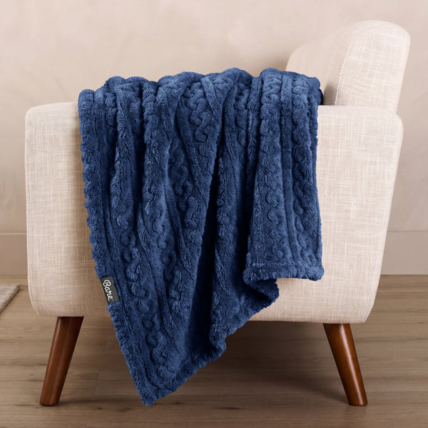 A textured blanket draped over the arm of a chair