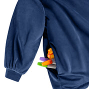 Close up of 1 pocket on the wearable blanket. Some markers and toys are sticking out of the pocket.