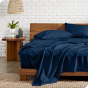 Bed with microfiber bedding against a white brick wall.