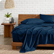 Microfiber sheets on a bed with a wooden headboard