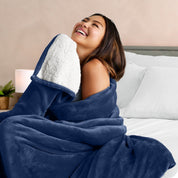 A woman smiling while wrapped in a sherpa blanket