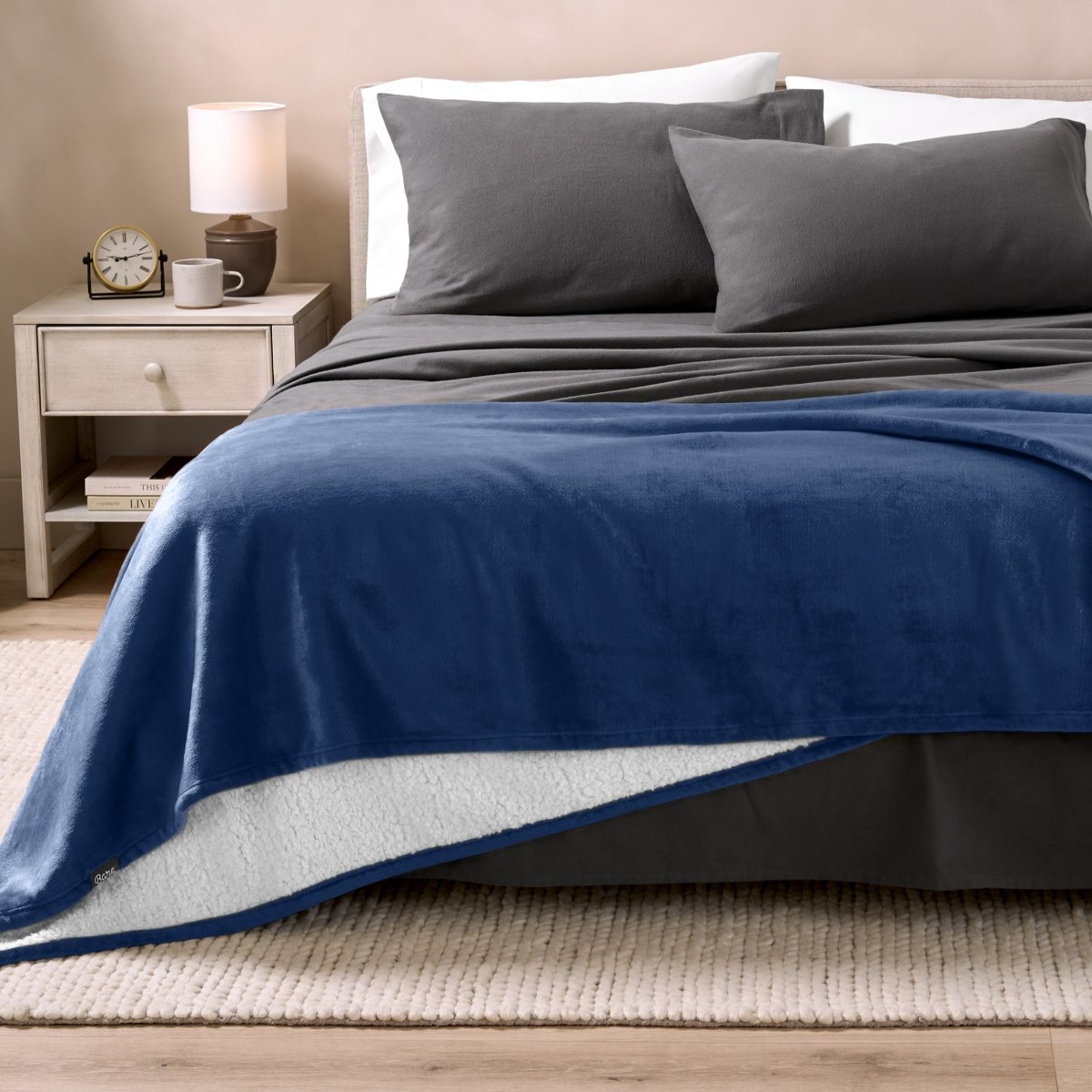 Bed with grey sheets and a sherpa blanket