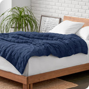 A weighted blanket draped over a bed