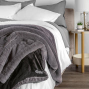 Blanket with 'Bare' branding on a bed in a bedroom setting