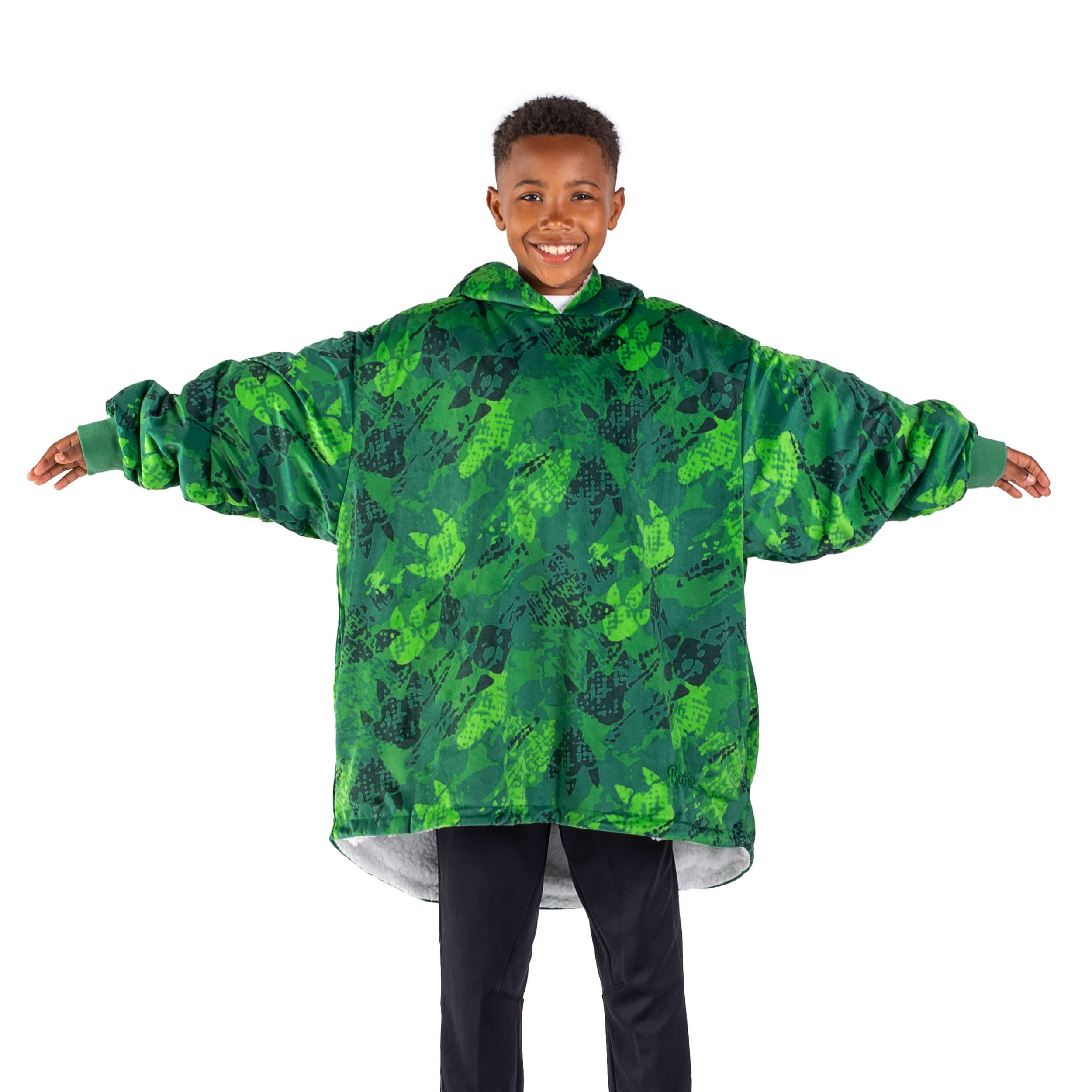 A boy standing with a wearable blanket on