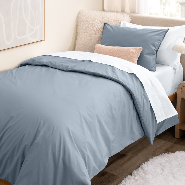 Dorm Bed made with white sheets and  light blue duvet cover