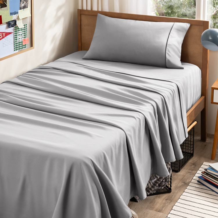 Grey sheets on bed in dorm room
