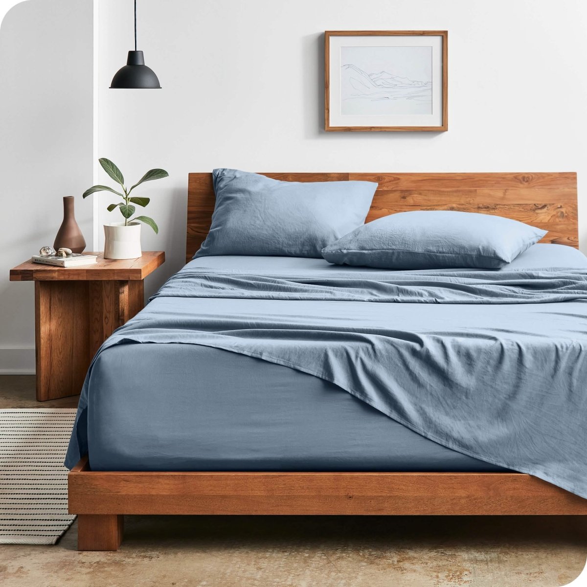 Modern bedroom with washed sheets draped over the end and the side of the bed