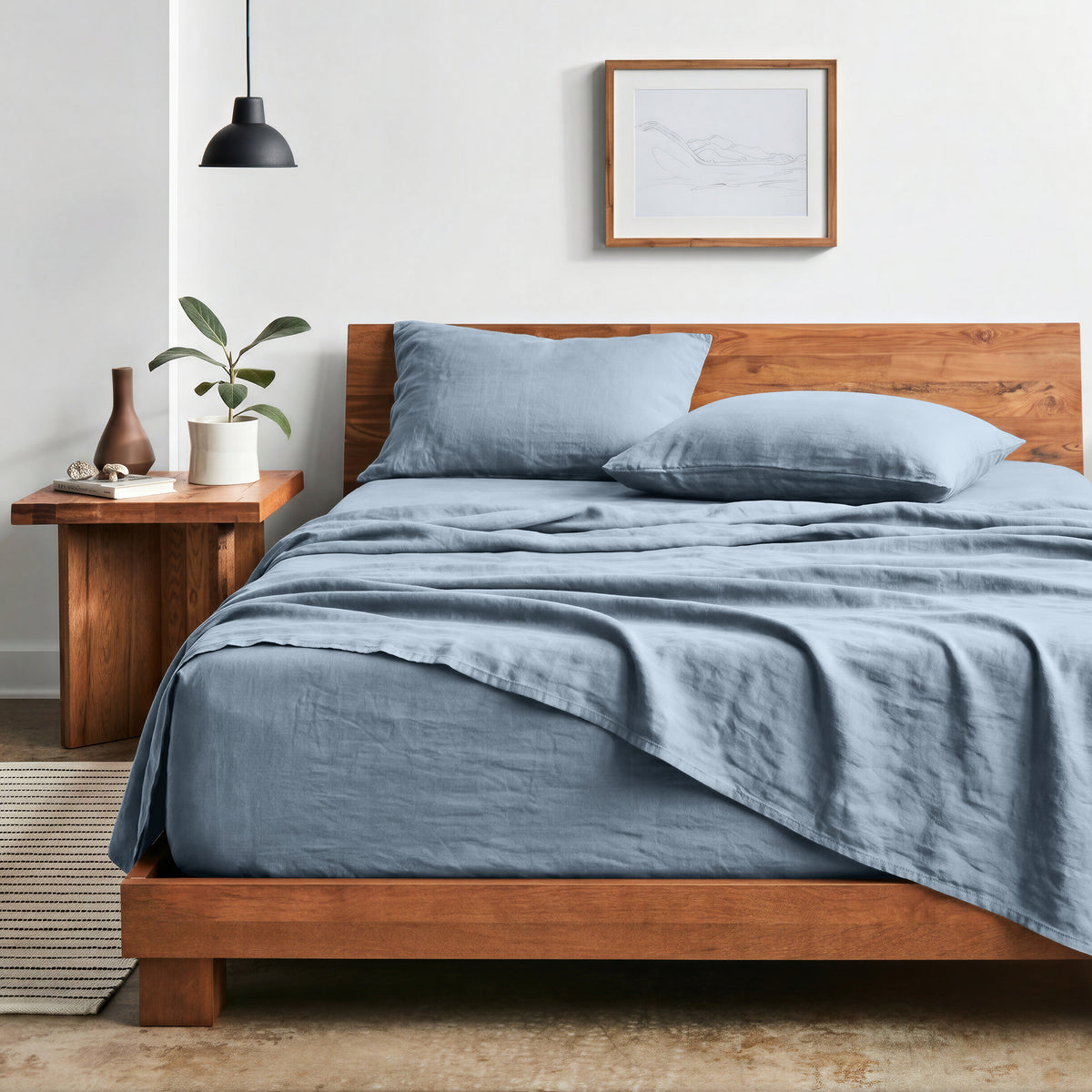 Bedroom with sheet set on a wooden bed frame and side table