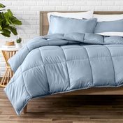 Comforter set on a bed with a white brick wall and plant in the background
