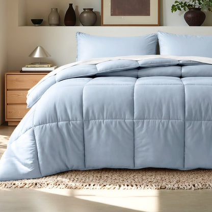 Comforter on a bed in a bedroom setting with a wooden nightstand and decorative items.