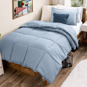 Bed with comforter and pillows in a dorm room