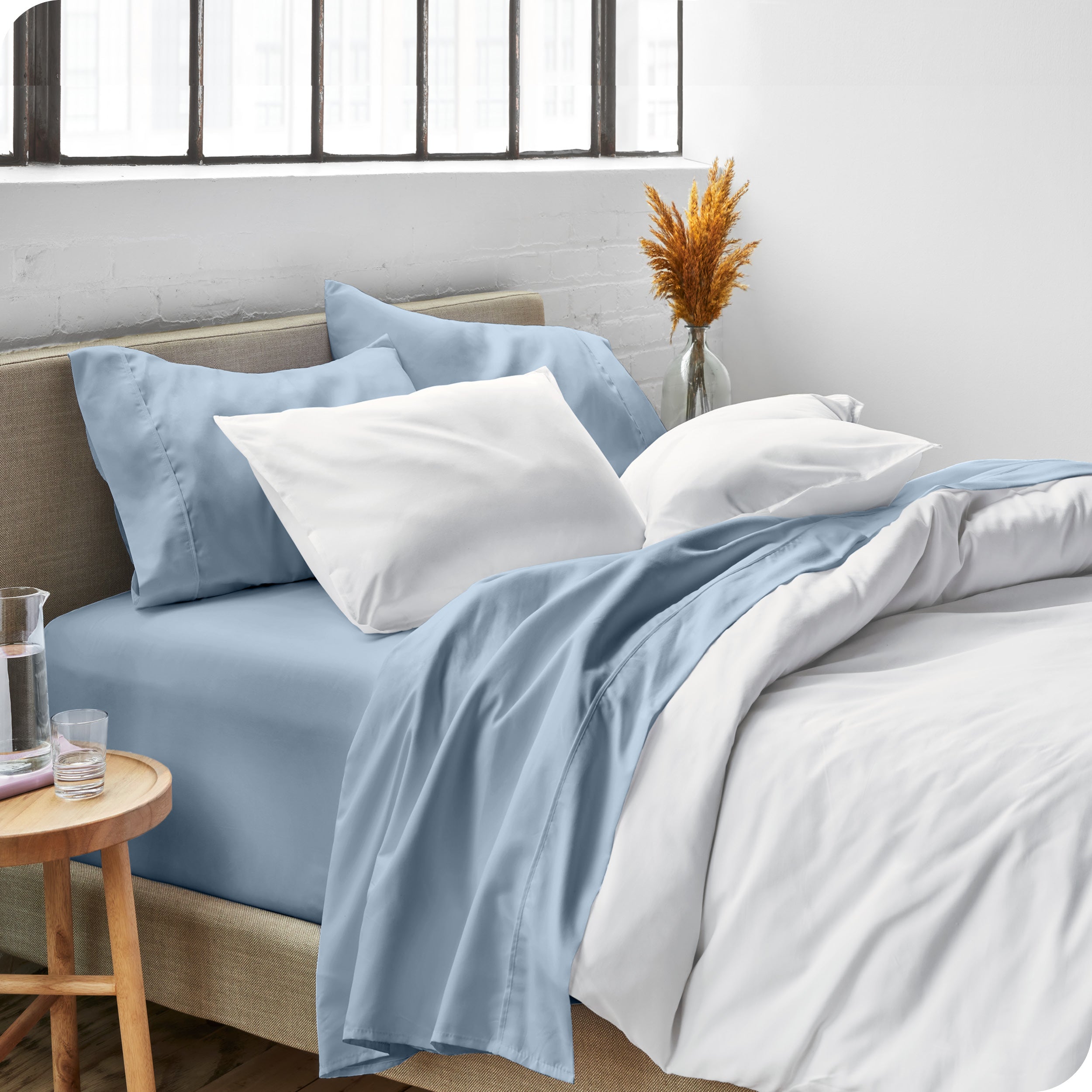 Sheets and a duvet cover on a bed in a bright bedroom