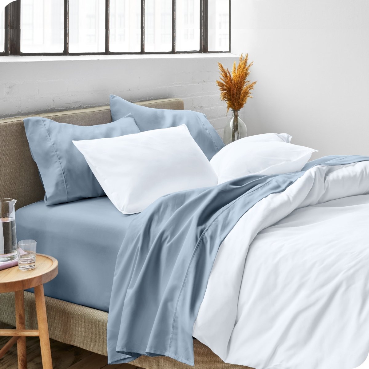 A side view of a bed made with microfiber sheets and a white duvet cover