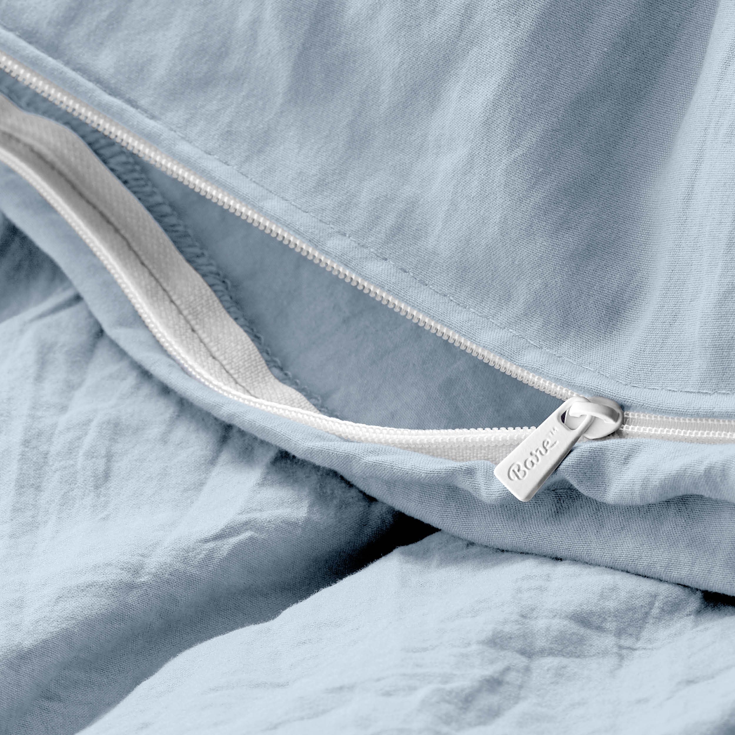 Close-up of a duvet cover with a zipper, featuring the brand Bare Home