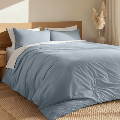 Bed with percale duvet cover set and wooden headboard in a room with a vase and decorative items.