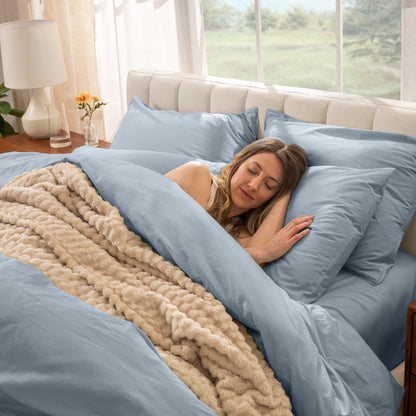 Woman sleeping in a bed with percale bedding and beige blanket