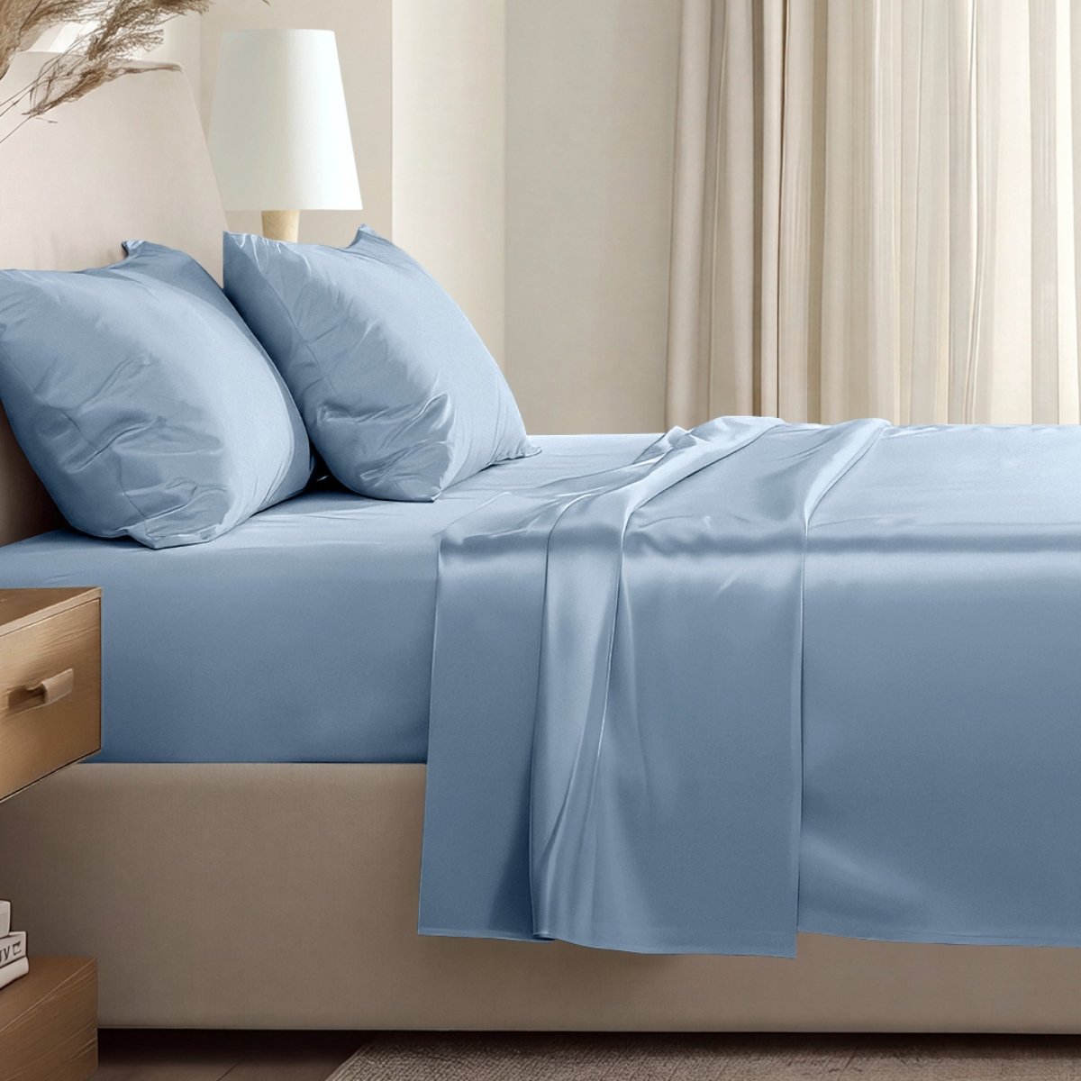 Sateen sheet set on a bed in a softly lit bedroom.