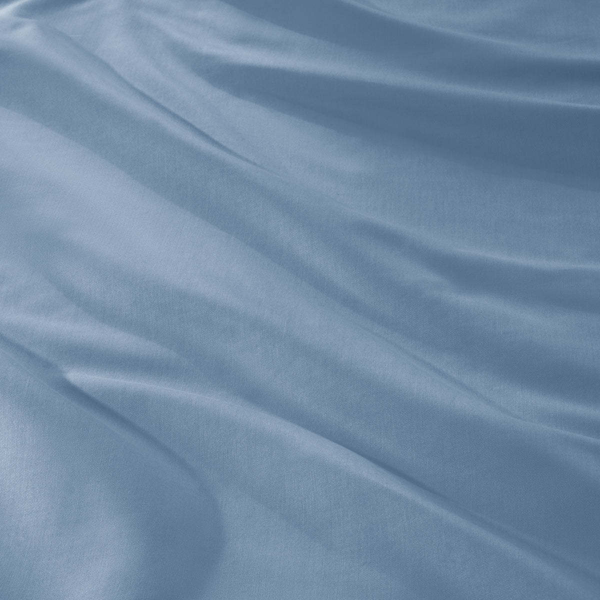 A close-up of draped sateen fabric with soft folds and a smooth texture.