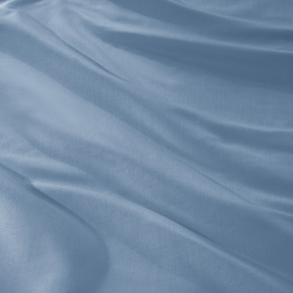 A close-up of draped sateen fabric with soft folds and a smooth texture.