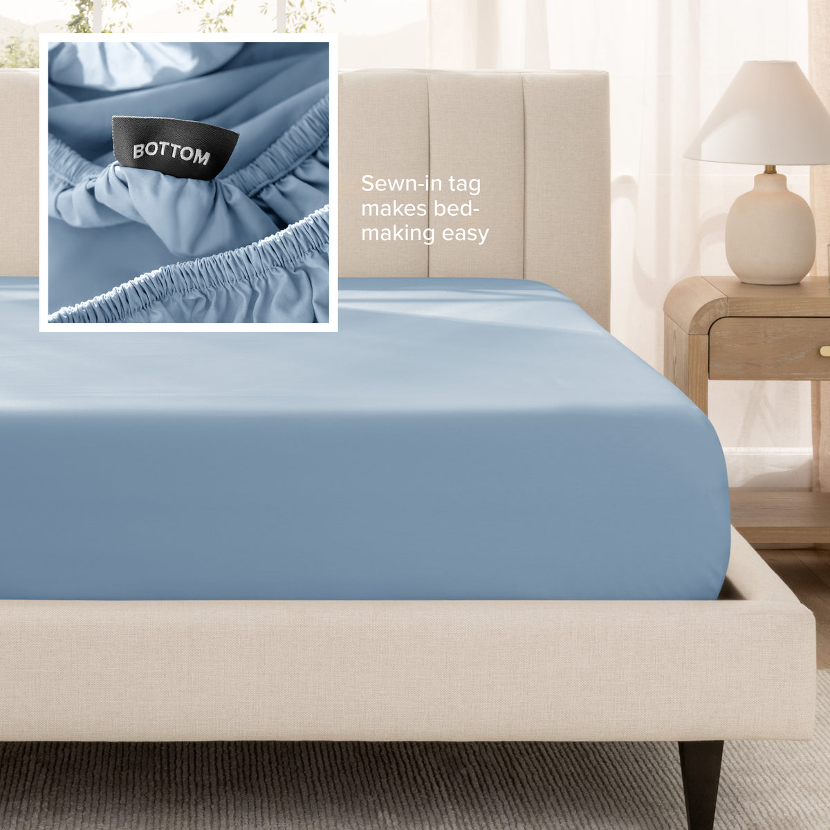 A fitted bed sheet shown on a bed. Text on the image says the sewn-in tag makes bed-making easy.