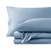 A sateen sheet set folded and stacked on a white background.