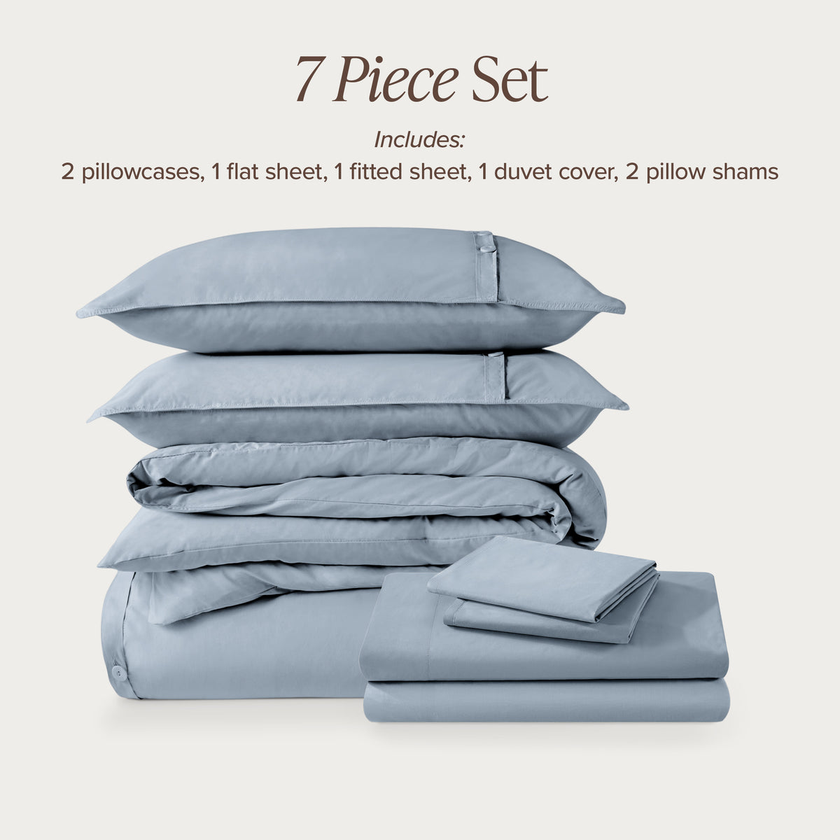 7-piece percale bedding set with pillowcases, flat sheet, fitted sheet, duvet cover, and pillow shams on a light background.