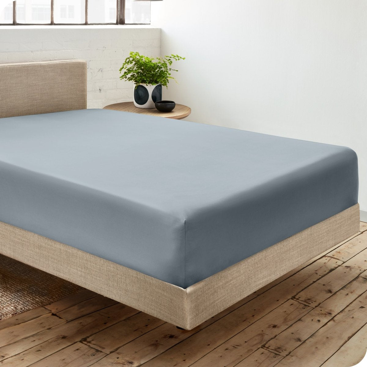 Diagonal view of room scene with percale fitted sheet on the bed