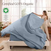 A woman is making a bed with organic cotton percale sheets