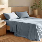 Bed with percale bedding and wooden headboard in a bedroom setting
