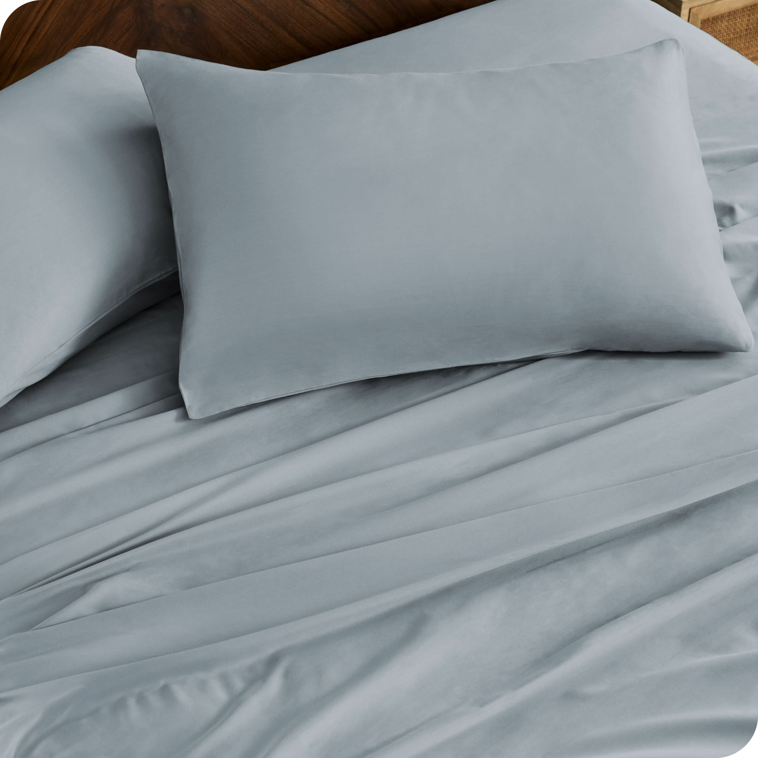 Close up of percale pillowcases and sheets on a bed