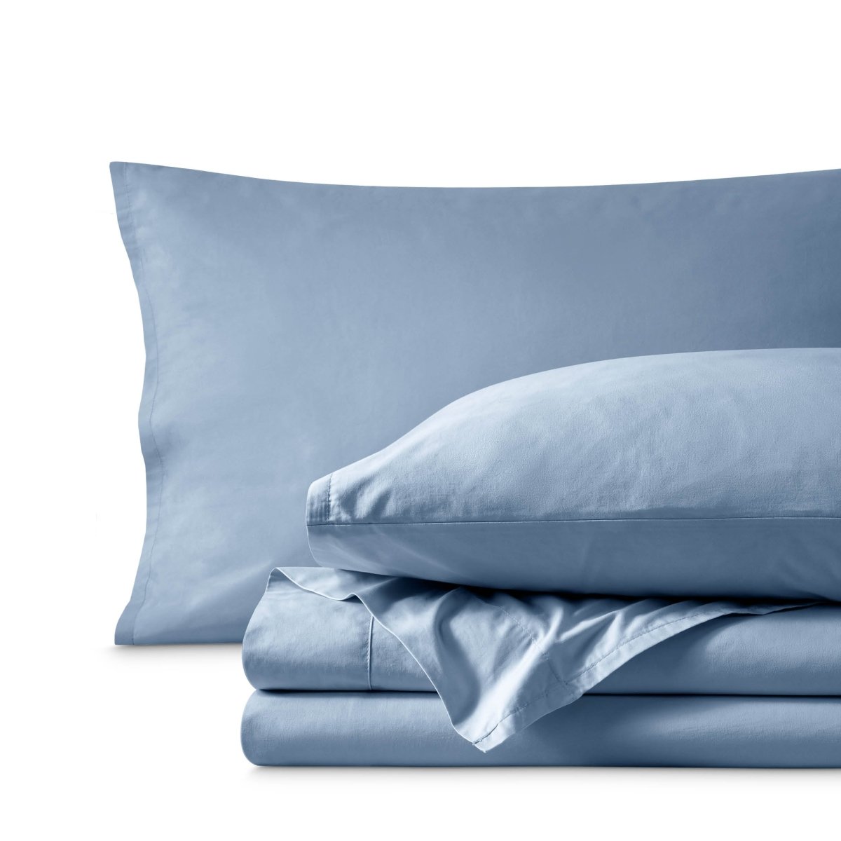 Percale bedding set including pillowcases and folded sheets arranged on a clean white background