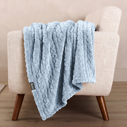 A textured blanket draped over a chair