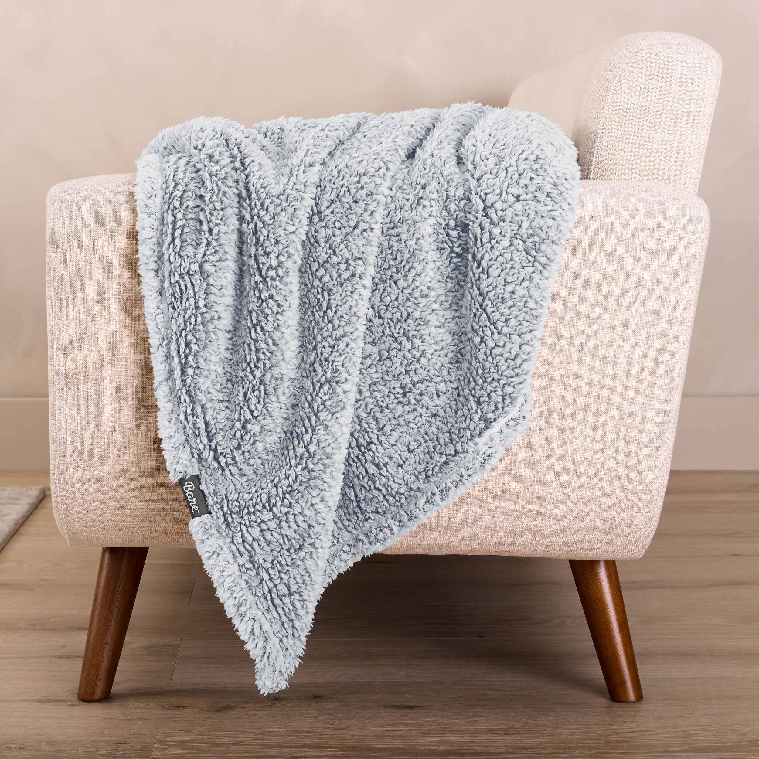 A sherpa blanket is hanging over the edge of a chair