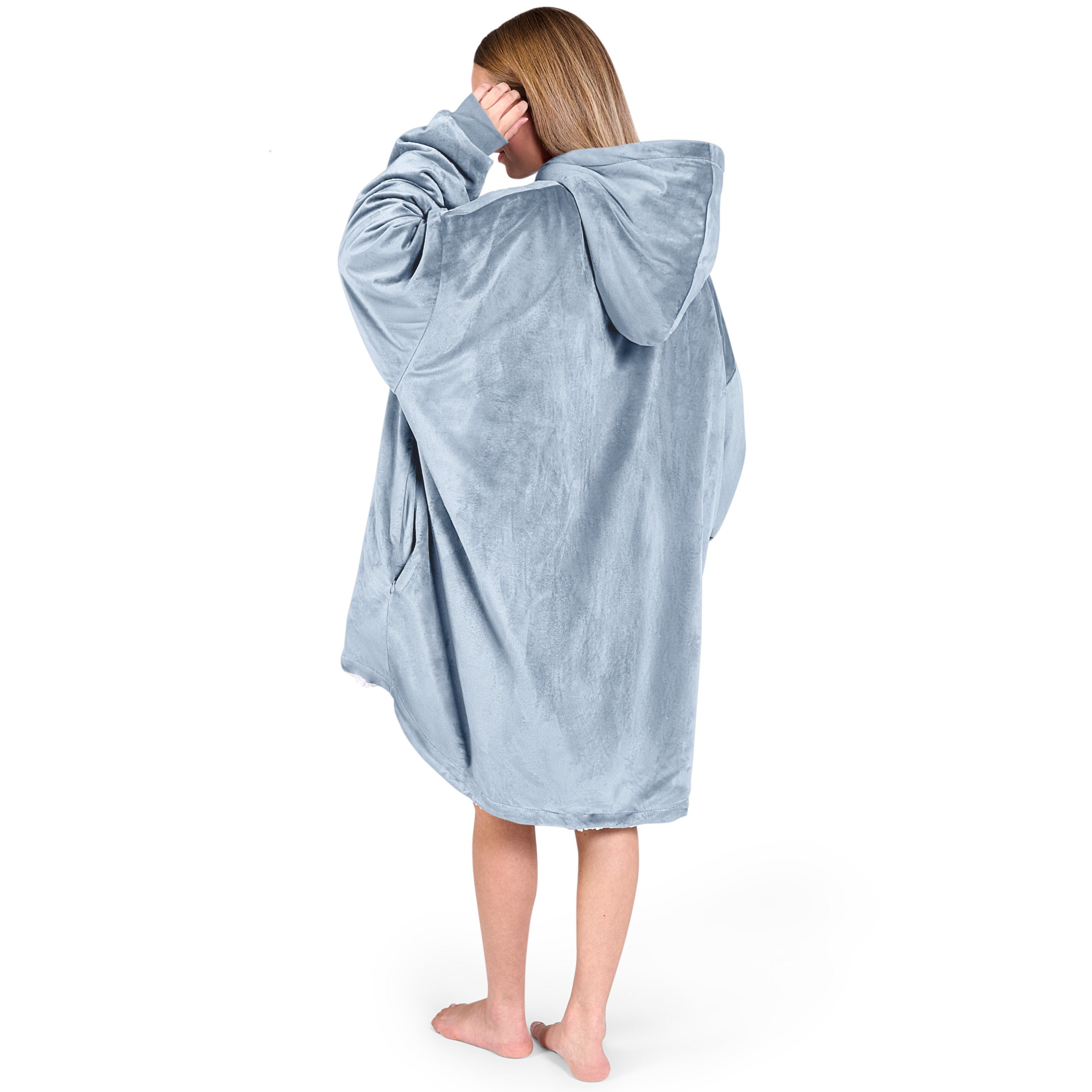 An adult with a hooded wearable blanket on