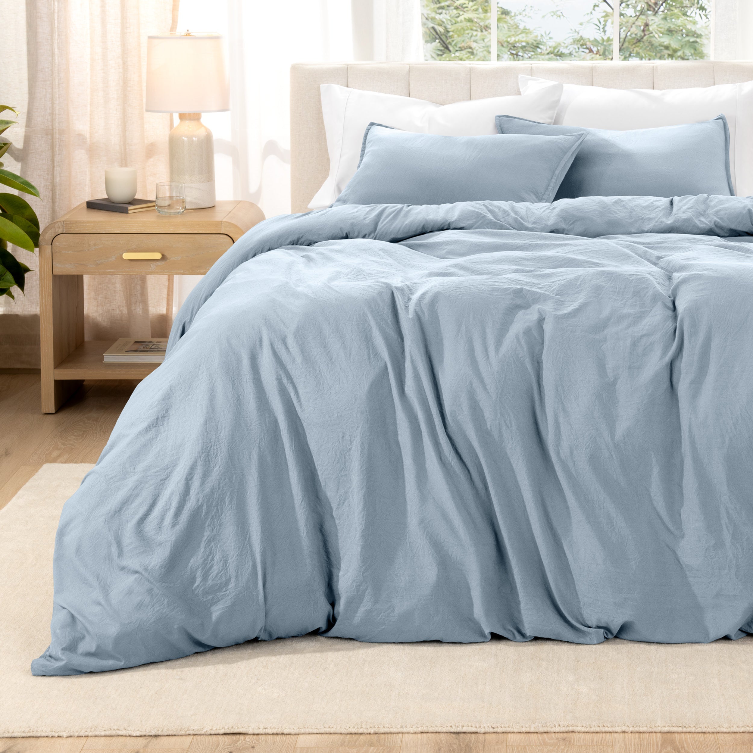 Washed bedding set on a bed with a nightstand in the background
