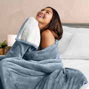 A woman smiling while wrapped in a sherpa blanket
